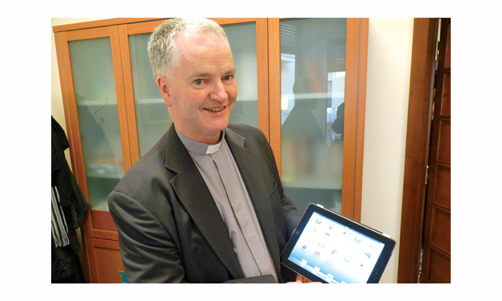 Priest holding an iPad