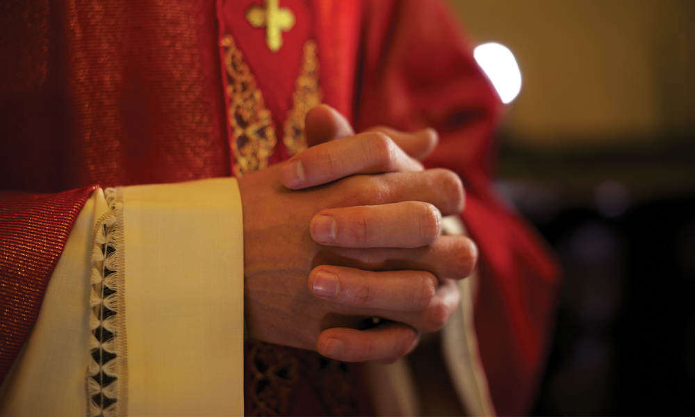 Priest's hand folded in prayer